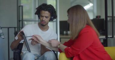 African American businessman in a wheelchair engages in a professional discussion with his colleague, addressing various business challenges and exploring solutions in an inclusive and diverse modern video