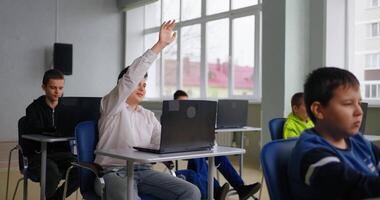 Smart Schoolboy Stretching Hand Up And Asking Teacher In Computer-Based Classroom video
