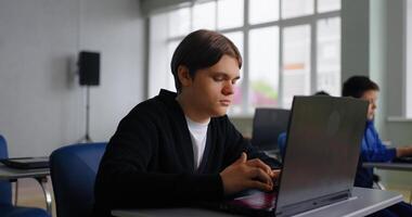 exame dentro meio escola, adolescentes alunos sentado às mesa com laptops dentro baseado em computador classe video