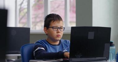 Smart Schoolboy With Eyeglasses Working With Laptop In Modern Computer-Based Classroom video