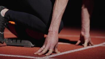 Enduring Sportsman Standing In Low Start Position, Runner Waiting For Signal For Run In Stadium video