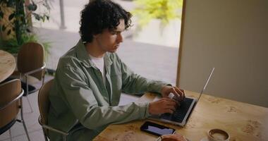 Freelancer Or Student Working With Portable Computer In Coffee Shop, Portrait Of Hispanic Young Man video
