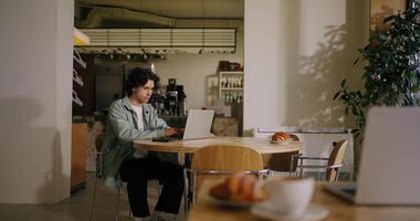 Hispanic Young Man Freelancer Working With Laptop In Cafe In Daytime, Student Programmer Learning video