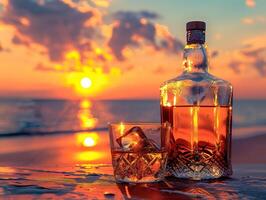 A bottle of liquor and a glass of liquor on a table by the ocean photo