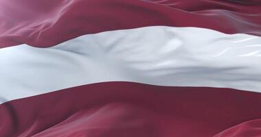 Flag of Latvia waving at wind with blue sky in slow, loop video