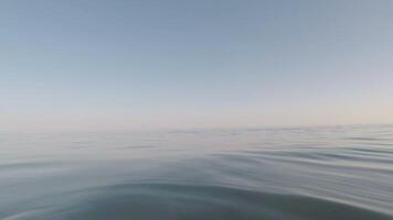View of blue calm sea at sunset with camera floating in the water video