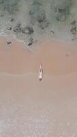 Caucasian woman in a bikini lying on the seashore on tropical beach in Thailand video