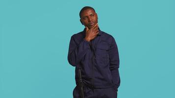 Security guard doing thinking hand gesture, being tasked with preventing criminal activity and detaining suspects. Portrait of pensive bodyguard rubbing chin, studio background, camera B video