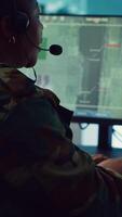 Vertical Female army operator registers important information from military surveillance system, working in control room base of operations to gather intelligence for the troops. National safety. Camera A. video