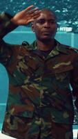 Vertical Standing at attention, the soldier executes the military salute gesture to present his respect and devotion as captain of the crew. Patriot army general saluting with right hand to his temple. Camera A. video