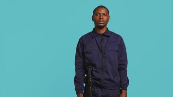 Security guard does surveillance for various organizations and venues, ensuring protection of property and personnel, studio background. Portrait of intimidating man in uniform crossing arms, camera B video