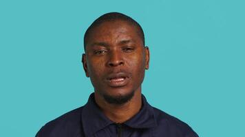 Portrait of security job employee yawning while at work detaining perpetrators, feeling tired. Patrol guard feeling exhausted after long night shift, isolated over studio background, camera A video