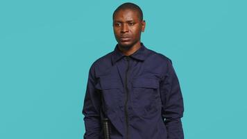 Portrait of security agent securing assigned post, pretending to shoot gun, studio background. African american guardian prepared to handle security breaches, doing pistol fingers gesturing, camera A video