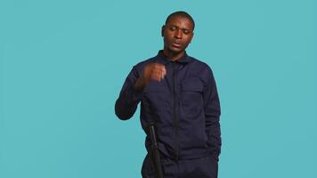 Security guard doing stop sign gesturing, being tasked with preventing criminal activity and detaining suspects. Portrait of stern bodyguard showing halt hand gesture, studio background, camera B video