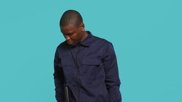 Security guard turning on flashlight, being tasked with preventing criminal activity and detaining suspects performing crimes. Portrait of bodyguard using lantern device, studio background, camera A video