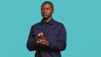 Portrait of security job employee shooting gun, detaining perpetrators while following legal protocols. Patrol guard follows conduct codes, doing pistol fingers gesturing, studio background, camera A video