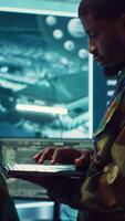 Vertical Military sergeant targeting enemy vessels on a gps satellite world map, operating from army power base monitoring room. Officer studies defense tactics on a tablet, command center. Camera A. video