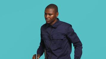 Portrait of security staff member tasked with evicting trespassers turns on flashlight. Patrolling agent maintains secure environment with lantern device, spotting people, studio background, camera A video