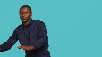Portrait of security guard pushing back intruders while overseeing premises. Private law enforcement worker shoving away trespassers with hands, studio backdrop, camera A video