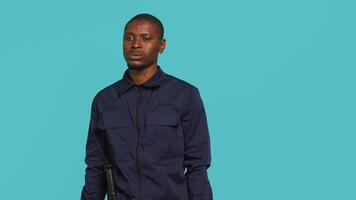 Security guard doing shush sign gesturing with finger, preventing public access in restricted area. Portrait of stern bodyguard urging people to keep quiet, studio background, camera A video