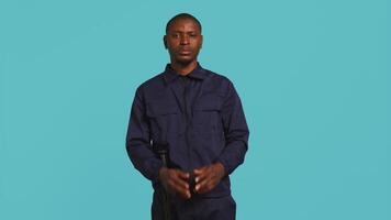 Security guard doing pretending to shoot gun hand gesture while being tasked with preventing criminal activity. Portrait of bodyguard doing pistol fingers gesturing, studio background, camera B video