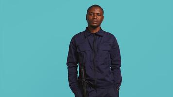 Portrait of security guard overseeing premises to prevent unwanted intrusion waving hand towards visitors. Private law enforcement worker doing greeting gesturing, studio backdrop, camera B video