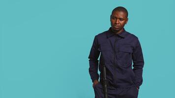 Portrait of security guard overseeing premises to prevent intrusion turning on flashlight to detect suspects. Private law enforcement worker using lantern device, studio backdrop, camera B video