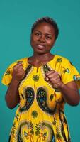 Vertical Strong rebel woman posing with clenched fists in studio, preparing for a fight and threatening with a protest symbol. Confident girl ready to strike, aggressive conflict and violence. Camera B. video