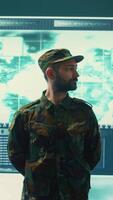 Vertical Military IT experts conducting surveillance and espionage activities using advanced technology and big screen. Governmental agency protecting against cyber threats and digital mercenaries. Camera B. video