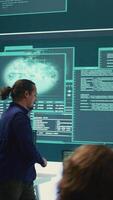Vertical Governmental hackers using advanced software to protect against cyber threats, working in team. Specialists on cyber security, data and network protection unite forces in high tech office. Camera B. video