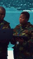 Vertical Special operations engineers examining surveillance footage to gather important information for a mission, working on reconnaissance in military headquarters. Army soldiers in command post. Camera A. video