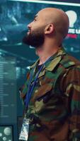 Vertical Commander managing cybersecurity measures to protect federal data from enemy breaches, working with his crew from a control center military base. Army officer ensures national safety. Camera A. video