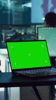 Vertical Army officer studies isolated greenscreen display on a laptop in control room, military power base personnel monitoring satellite world map for federal operations. Commander in uniform. Camera A. video