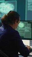 Vertical Governmental IT expert monitoring cyber threats on a computer and big screen, high tech agency office. Hackers examining cyber defense measures for prevention of dangerous digital threats. Camera B. video
