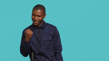 Cheerful security guard celebrating achievements during protection job shift. Portrait of joyous bodyguard feeling satisfied after completing tasked orders, studio background, camera A video