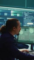Vertical Cyber security experts in a governmental hacking room working on securing networks. Hackers focusing on malware detection, cyber operations and protection against digital mercenaries. Camera B. video
