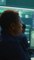 Vertical Governmental hackers analyzing big data for cyber threat detection, working at agency desks. Professional expert woman analyzes cyber intelligence and prevention of digital threats. Camera B. video