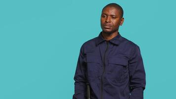 Portrait of security staff member tasked with evicting trespassers, pretending to shoot gun. Patrolling agent maintains secure environment, doing pistol fingers gesturing, studio background, camera A video