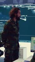 Vertical Staff sergeant briefing his army troops crew with details of a new mission, operating command center devices to monitor radar CCTV footage and provide information to people in the field. Camera B. video