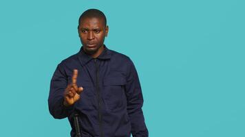 Portrait of security agent doing no gesturing with finger, refusing people entry while securing assigned post. Guardian does disapproving hand gesture, handling security breaches, camera A video
