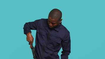 Portrait of security staff member tasked with evicting trespassers, intimidating them with baton. Patrolling agent maintains secure environment using truncheon weapon, studio background, camera A video