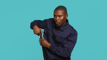 Security guard turning on flashlight and preparing baton to detect and detain suspects. Portrait of bodyguard using lantern and truncheon to subdue criminals, studio background, camera A video