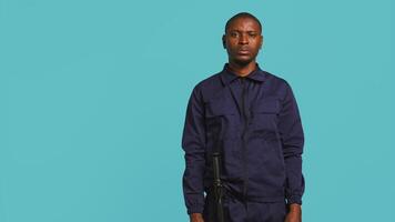 Security guard in threatening pose, tasked with preventing criminal activity and detaining suspects performing crimes. Portrait of menacing bodyguard crossing arms, studio background, camera B video