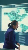 Vertical Cyber defense team working in a governmental security operations center. Experts ensuring cybercrime prevention and data breach protection, examining information on a big screen. Camera B. video
