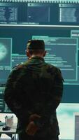 Vertical Military hackers working on cyber security in a high tech government center. Focusing on network protection, encryption and preventing cyber attacks to safeguard state secrets. Camera B. video