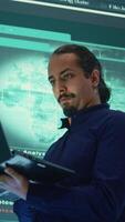 Vertical Governmental hacker expert working on securing digital information, analyzes intelligence on big screen. Specialist works to prevent cyber threats with advanced technology, cyberterrorism. Camera B. video