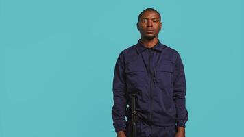 Security guard tasked with preventing criminal activity and detaining suspects stealing, damaging property, or performing other crimes. Portrait of intimidating bodyguard, studio background, camera B video