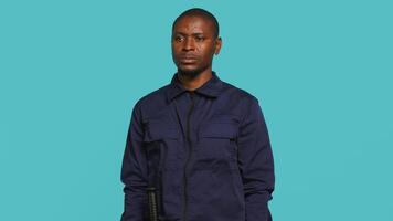 Security guard in threatening pose, tasked with preventing criminal activity and detaining suspects performing crimes. Portrait of menacing bodyguard crossing arms, studio background, camera A video