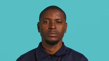 Headshot portrait of security guard at work smiling and overseeing premises. Joyful private law enforcement worker grinning while doing job, close up shot, studio backdrop, camera A video