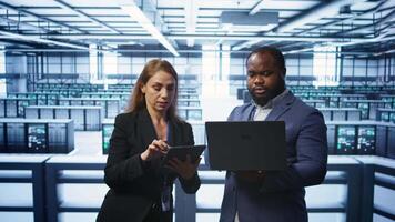 Manager in data center supervising worker running error checking utilities to fix errors. Supervisor in server farm overseeing engineer repairing network issues affecting rigs performance, camera B video